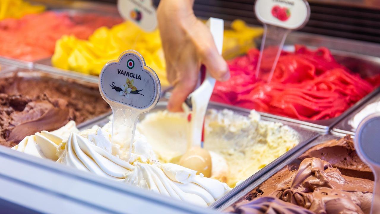 Borgo toscano con gelateria artigianale, turisti gustano gelato in un'atmosfera pittoresca.