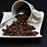 Chicchi di caffè tostati su un tavolo, simbolo di energia e vitalità istantanea.